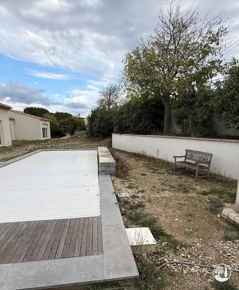 Avant : piscine sous sa bâche, terre nue et gravats autour
